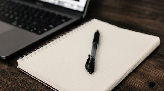 Cuaderno y ordenador sobre una mesa de trabajo